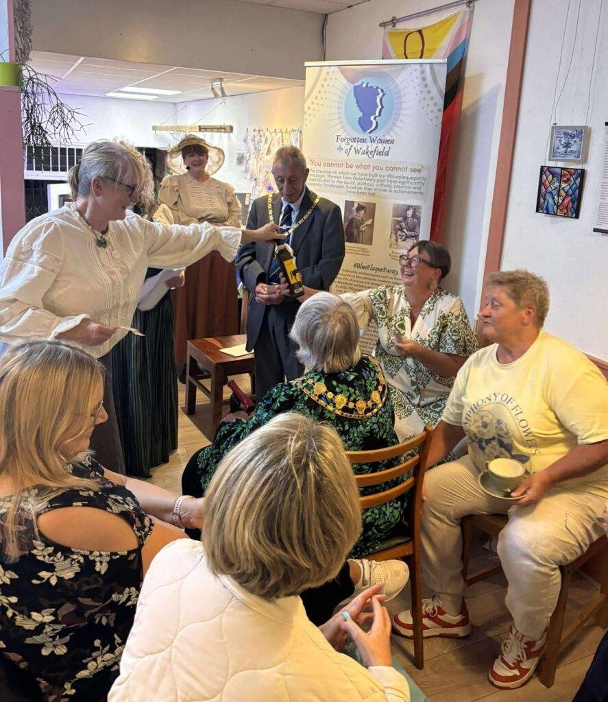 A group of people at a talk in a cozy looking cafe. 