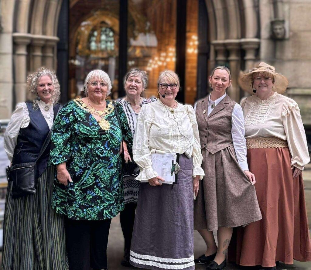 A mayoral figure with several others in Victorian dress. 