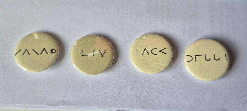 Badges with brail letters on them. 