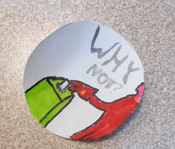 Badge created by a child showing someone putting a vote into a ballot box with the slogan "Why not?" in women's suffrage colours